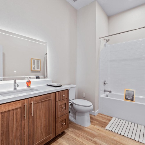 Bathroom options with thoughtful details Bathroom with a tub and backlit mirror over vanity in Province's 1 bedroom apartment in San Gabriel Valley.